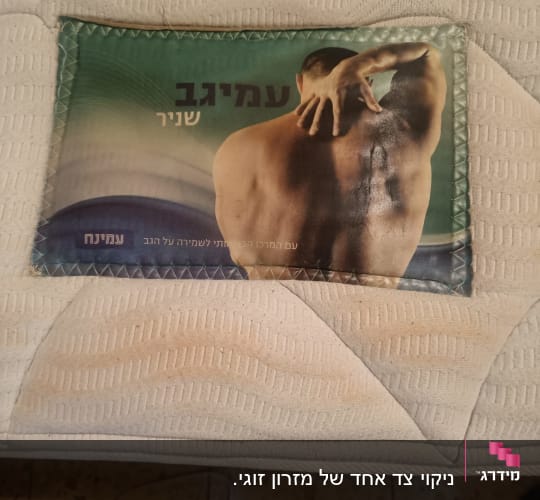 תמונה של מזרן עם כתם ושלט פרסומת